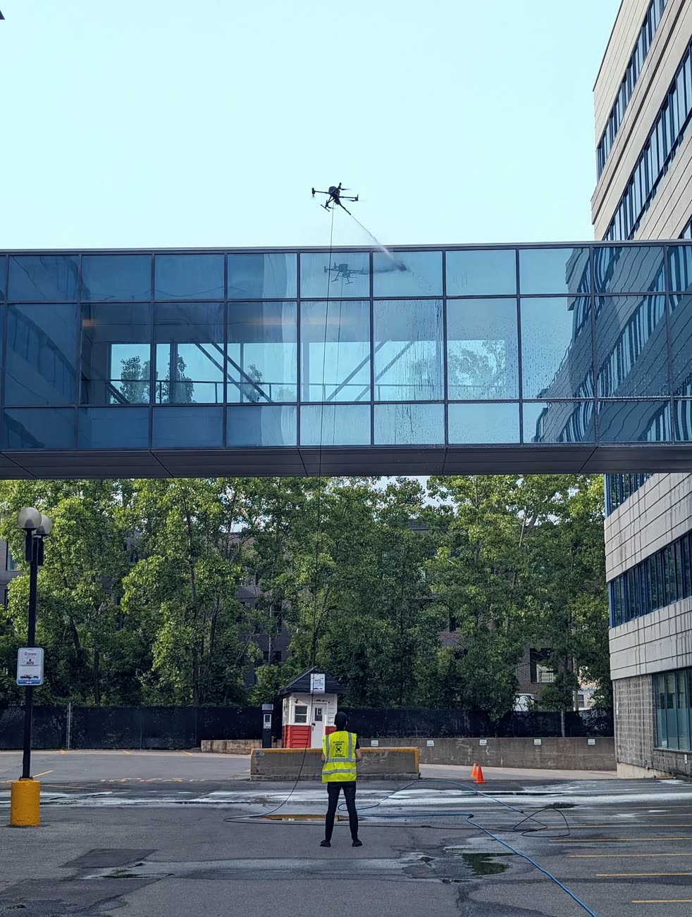 Drone operator cleaning building facade