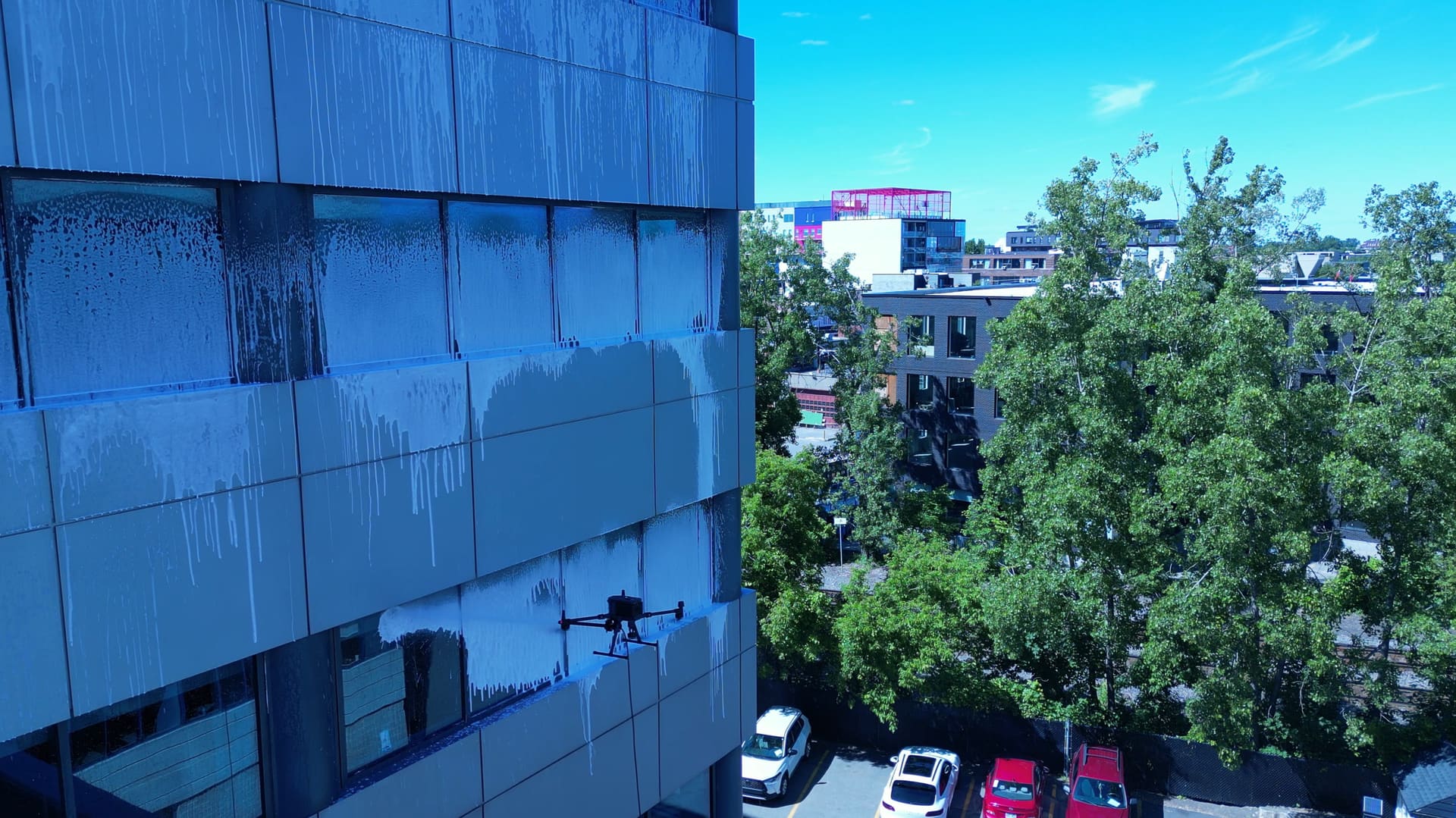 Drone cleaning a high-rise glass facade for Vitres.net
